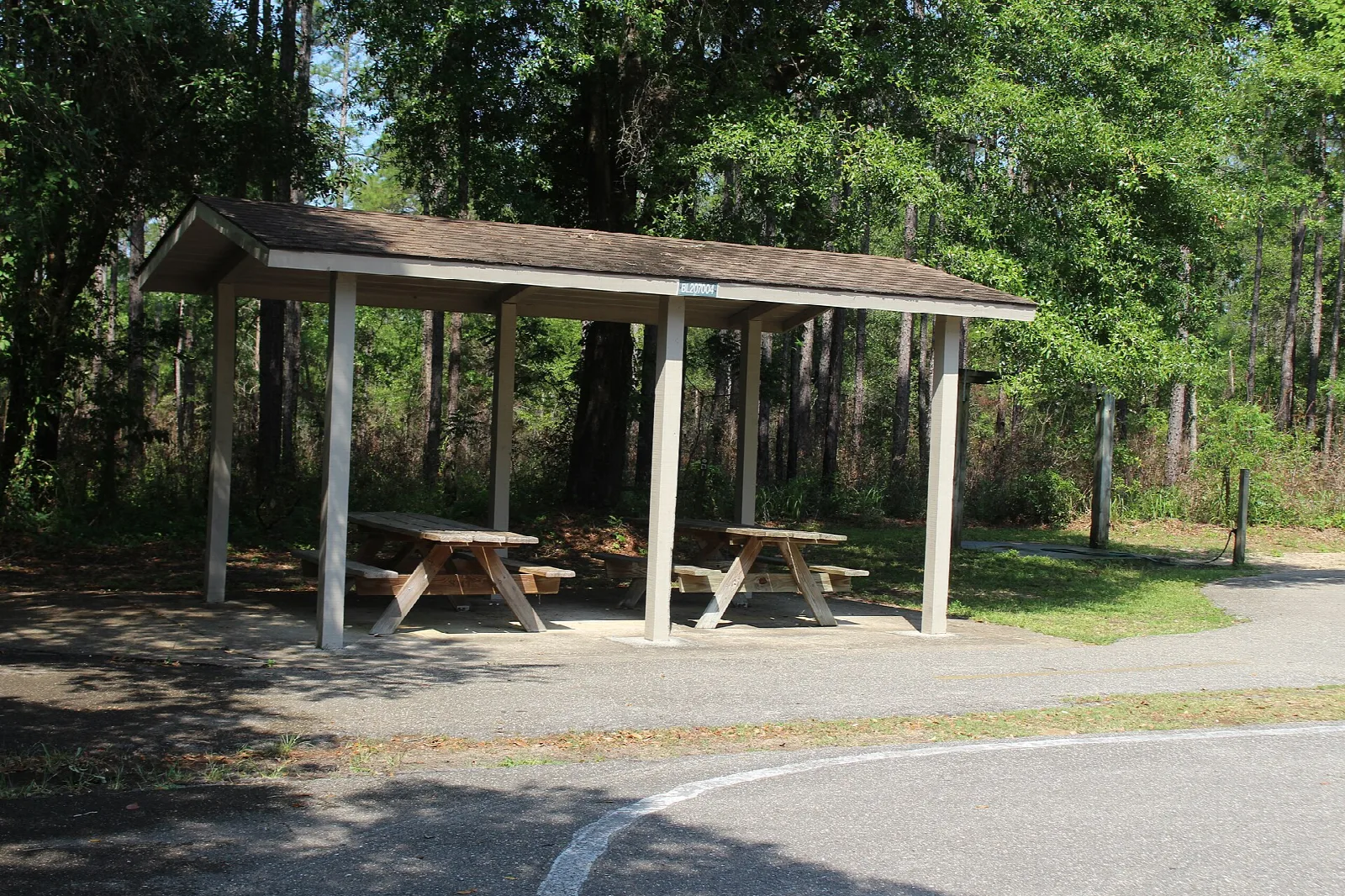 Picnic shelter with tables beside a paved lot