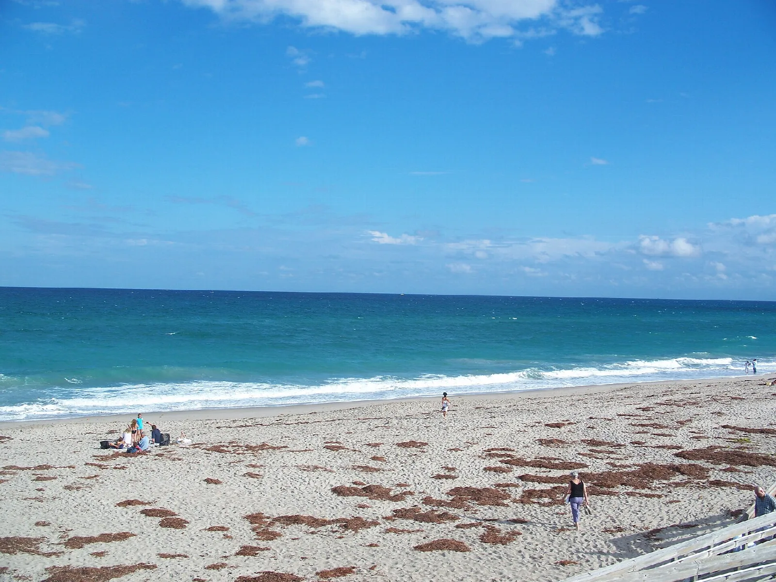 Wide sand beach with turquoise water and breaking waves