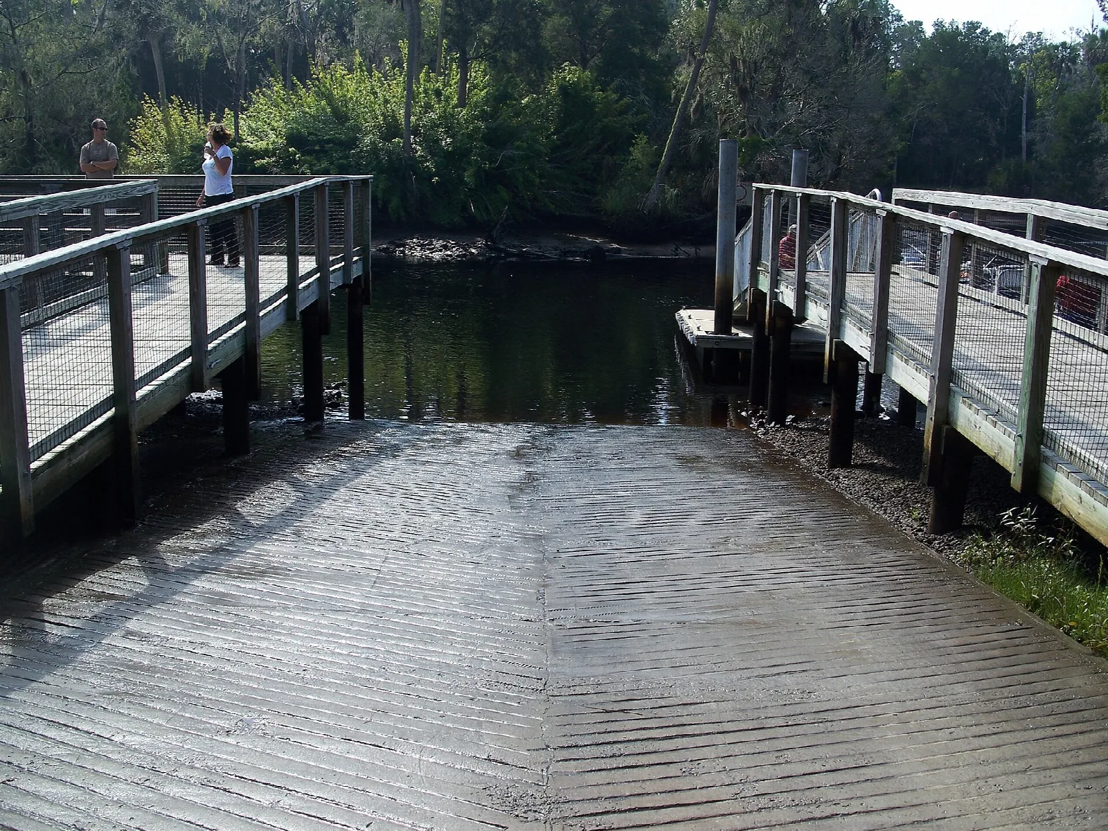 Wooden boat ramp running into a dark river