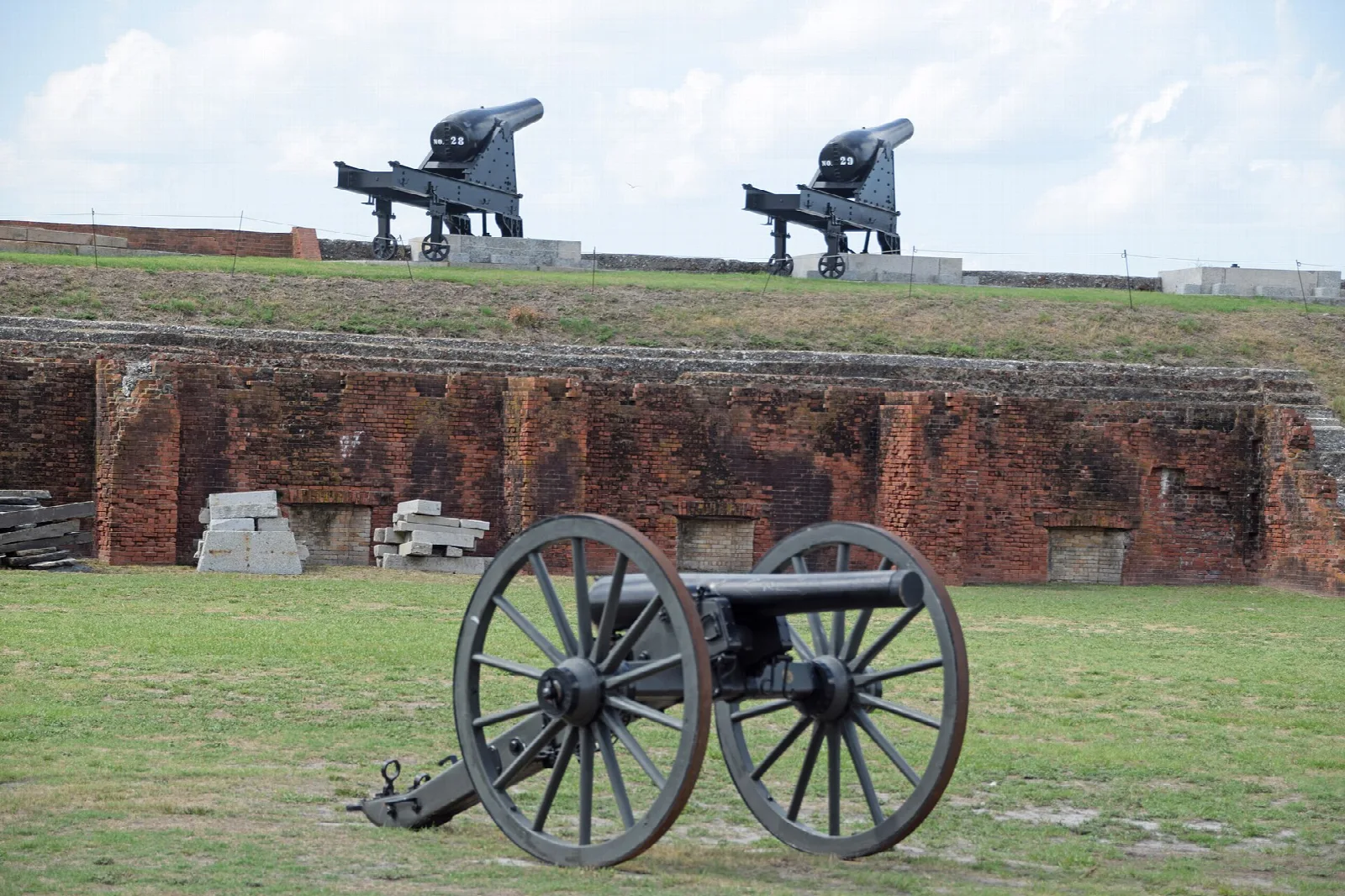 Cannon on a carriage in front of brick ramparts