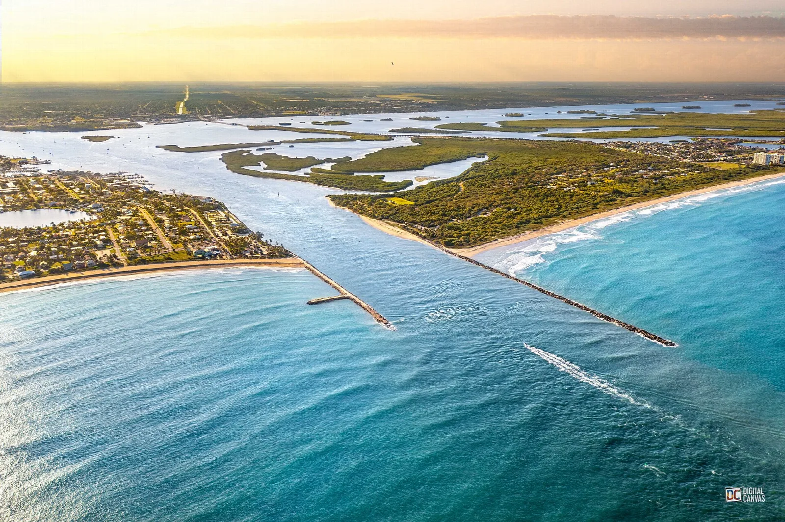Aerial view of the inlet with jetties and a long beach