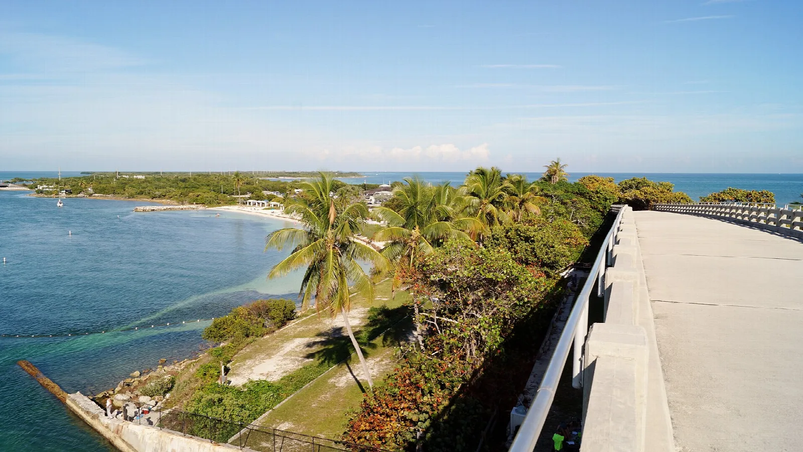 Road on an old bridge above a green island shore and blue water