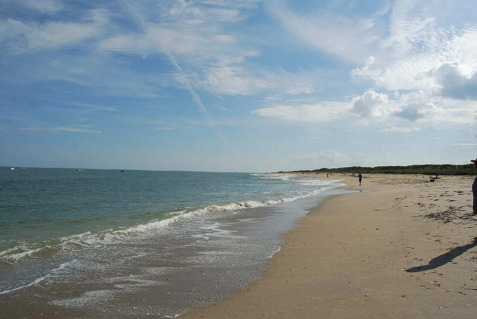 Sandy beach with gentle surf and a long shoreline