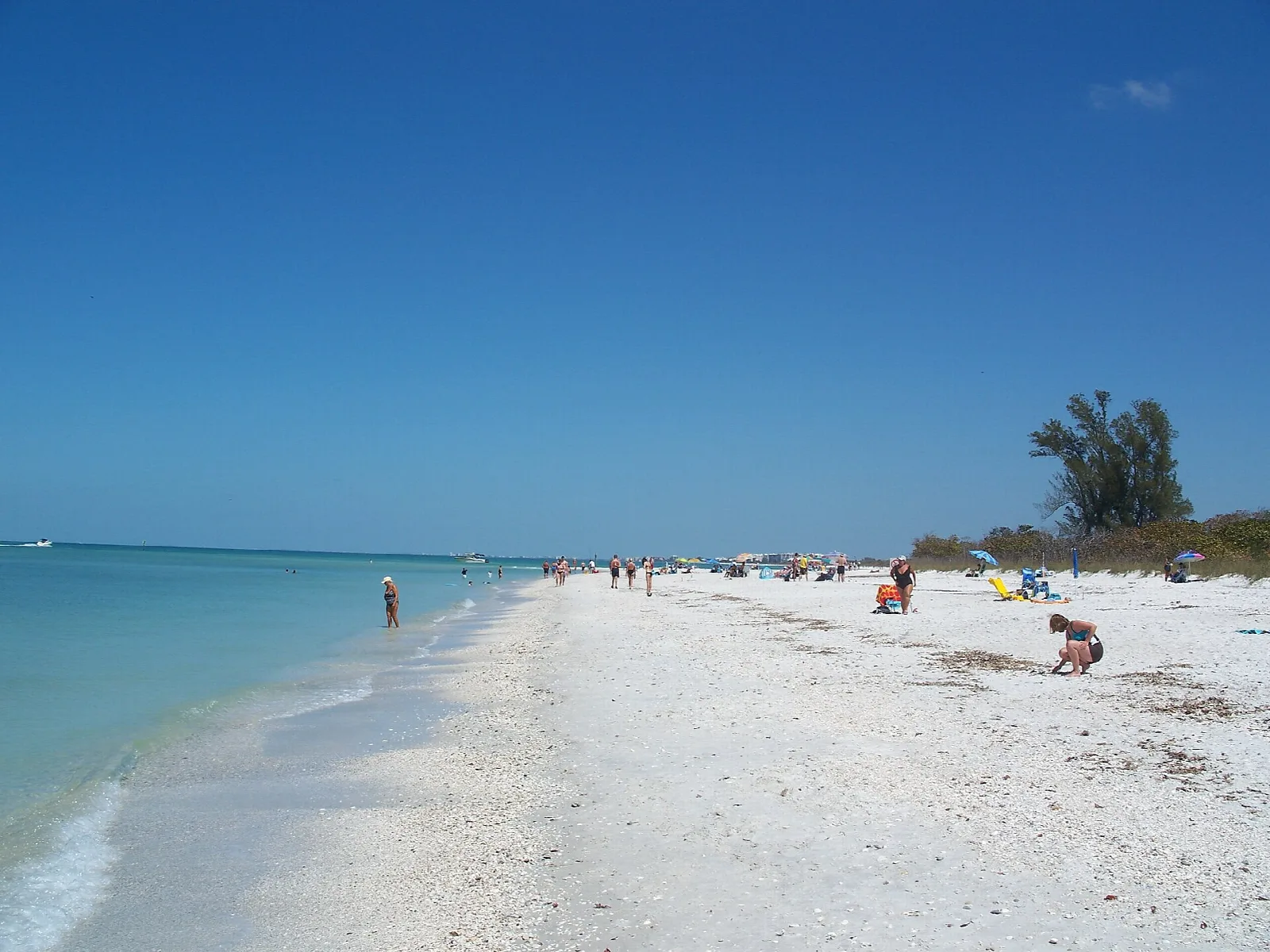 Wide white sand beach and turquoise Gulf with a few people