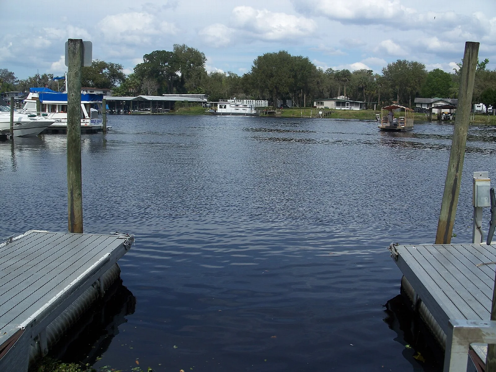 Wood docks on a river with houses and boats beyond