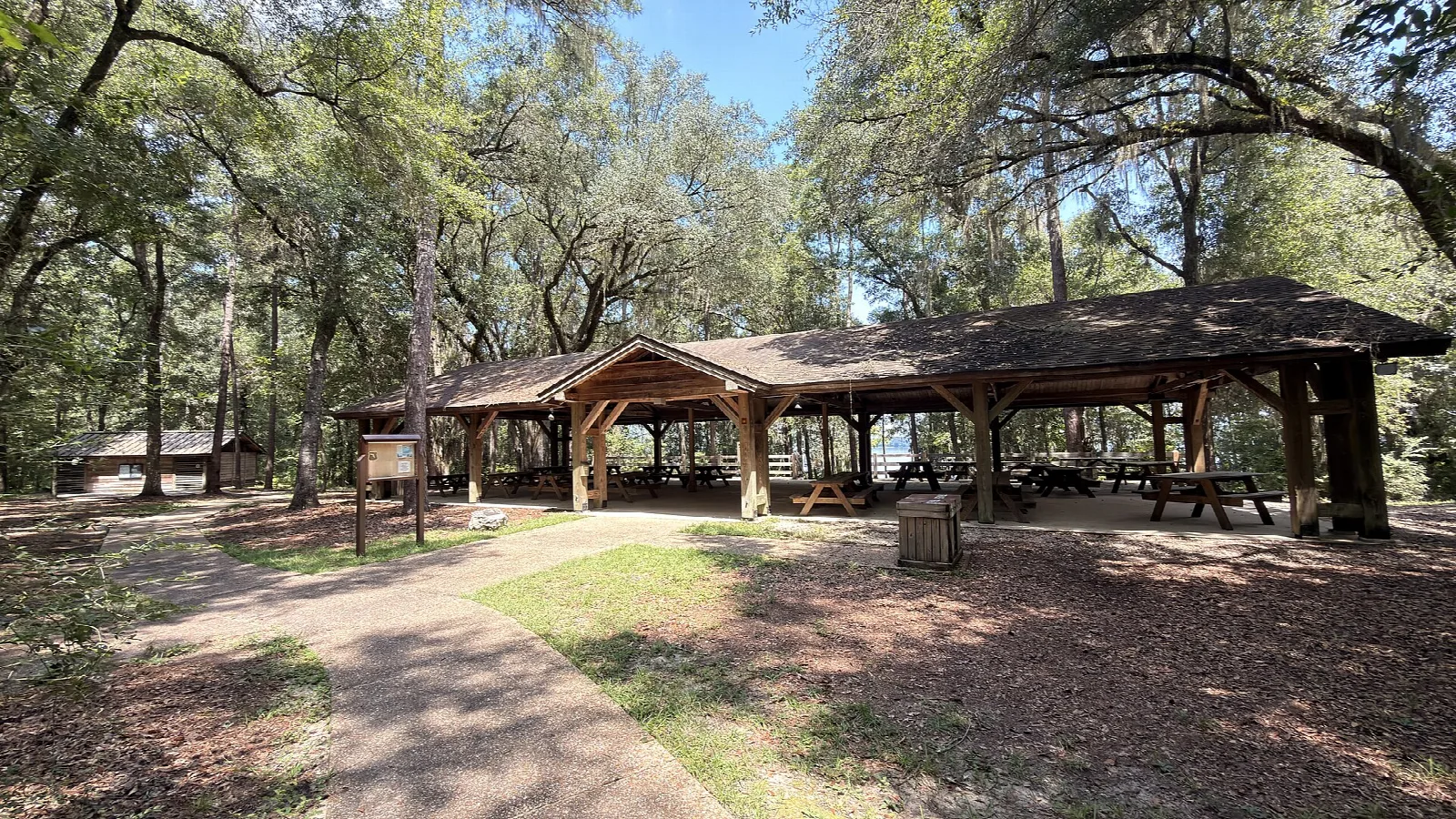 Open wood pavilion with picnic tables under oaks