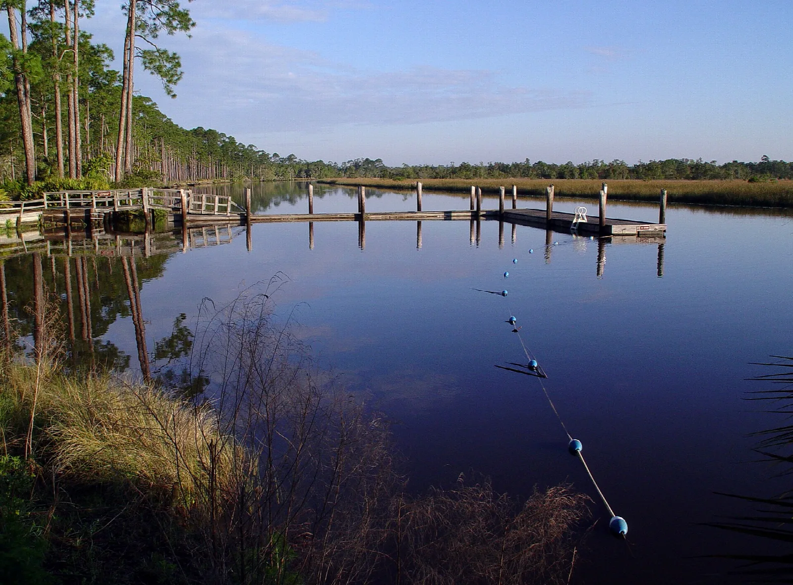 Wood piers on calm river water at dusk