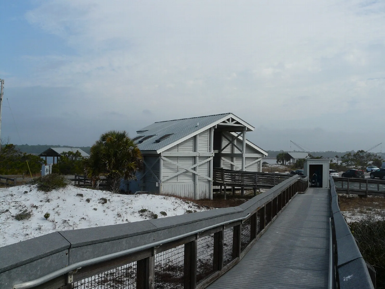 Raised walkway across dunes to a gray beach house