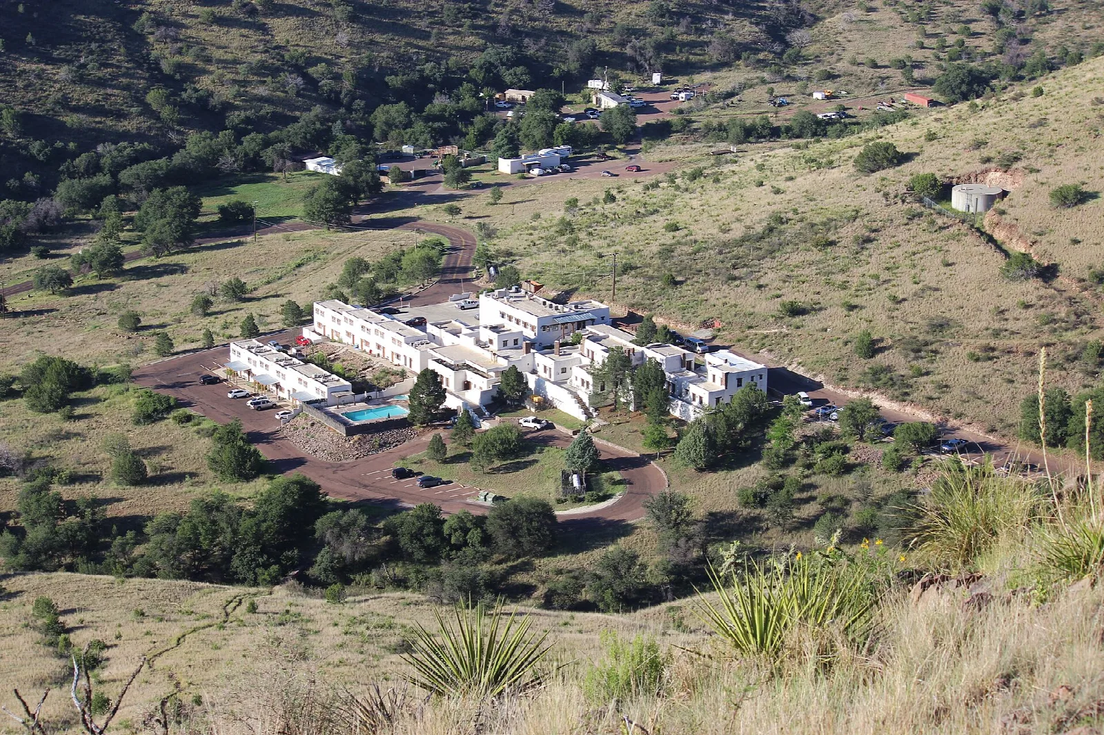 White adobe lodge buildings among green hills