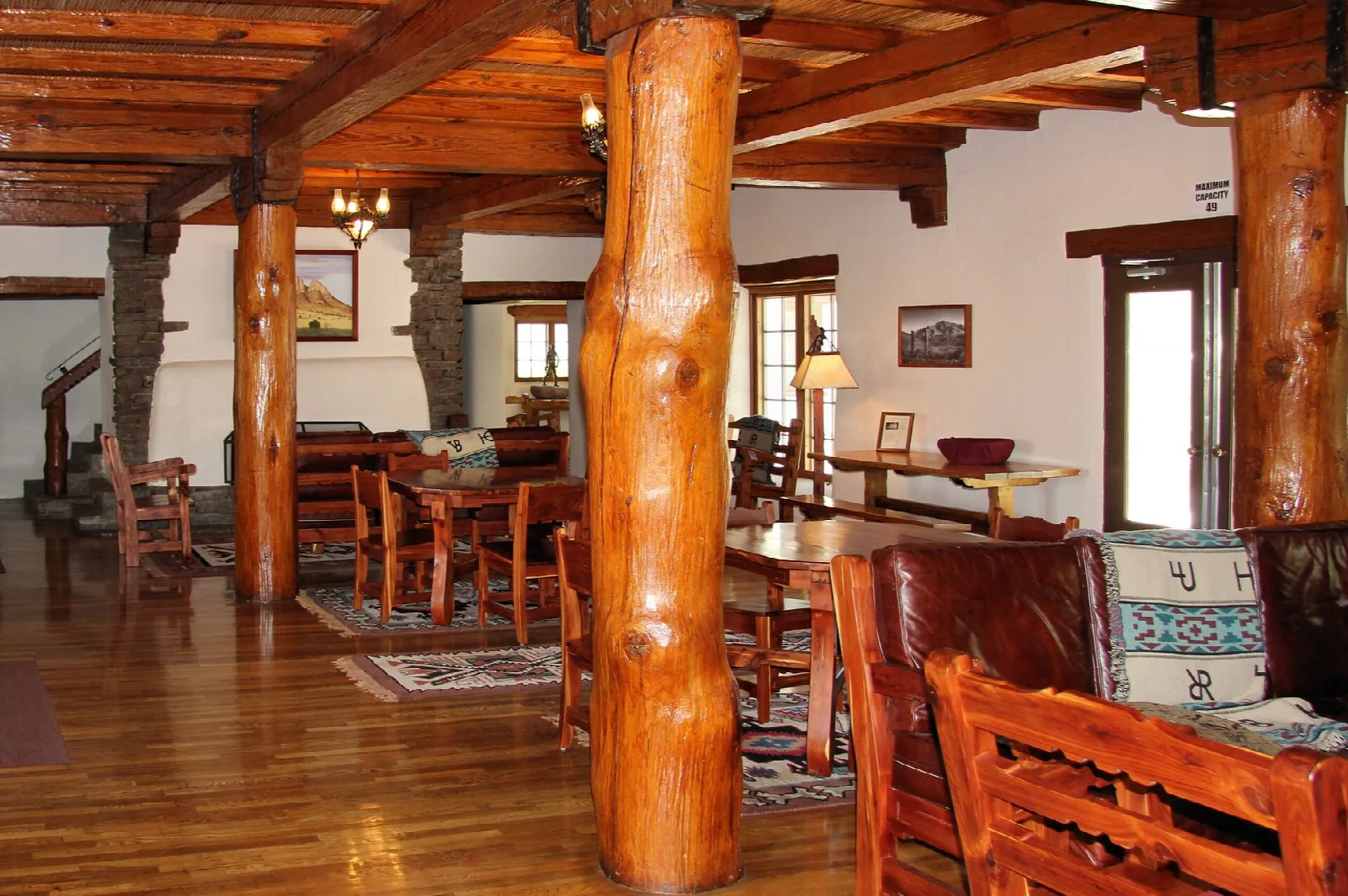 Lodge lobby with log pillars, wood floor and leather chairs
