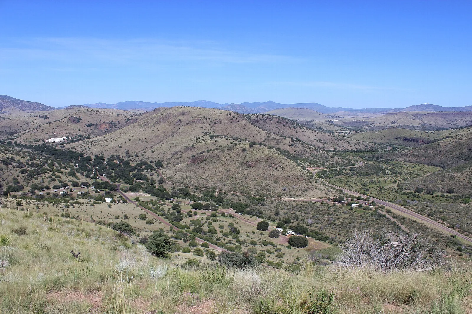 Grassy desert hills and valley under a blue sky