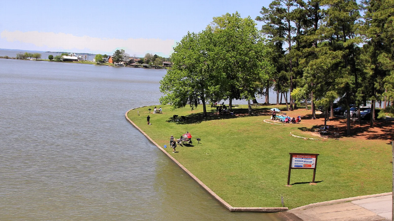 Grassy day use point with trees reaching into the lake