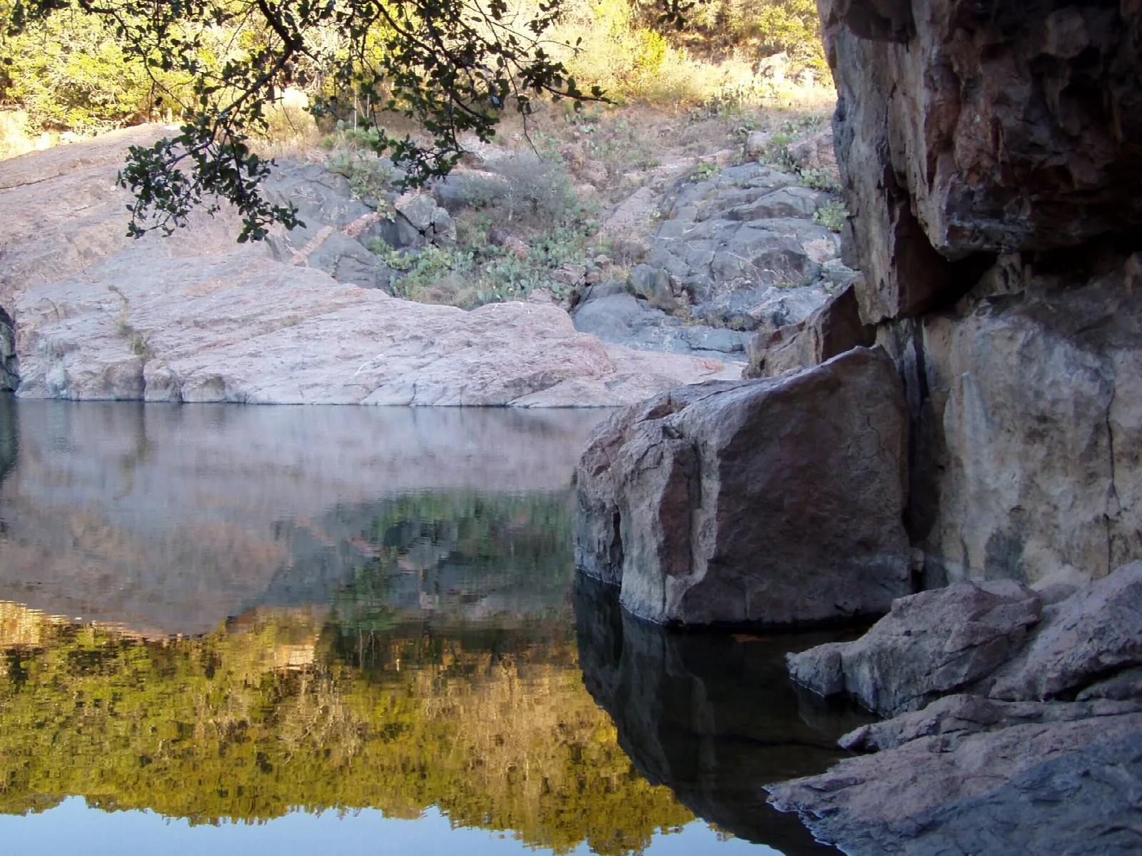 Still pool reflecting pink granite boulders