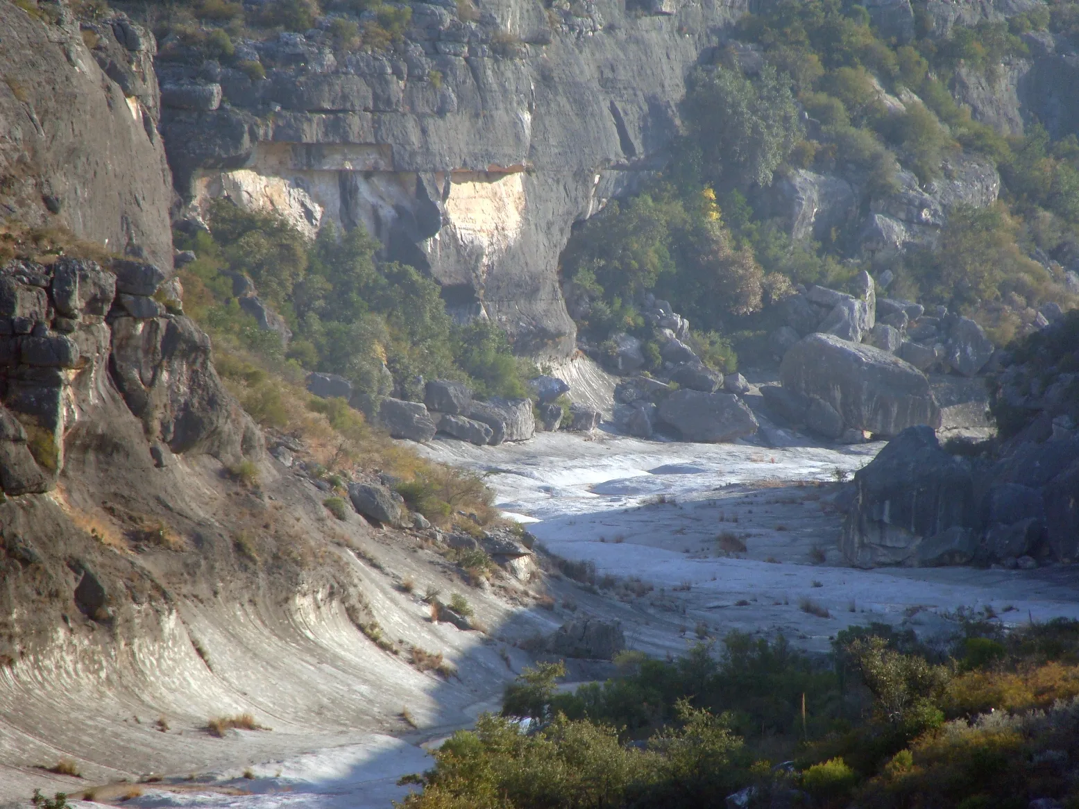 Rocky canyon walls above a pale dry riverbed