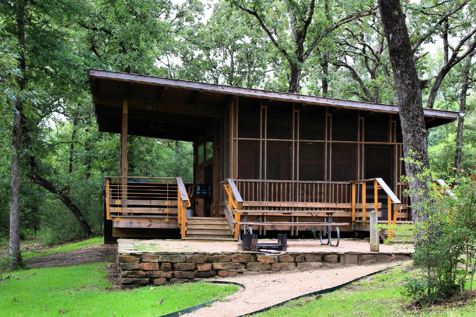 Wood cabin with a screened porch among trees