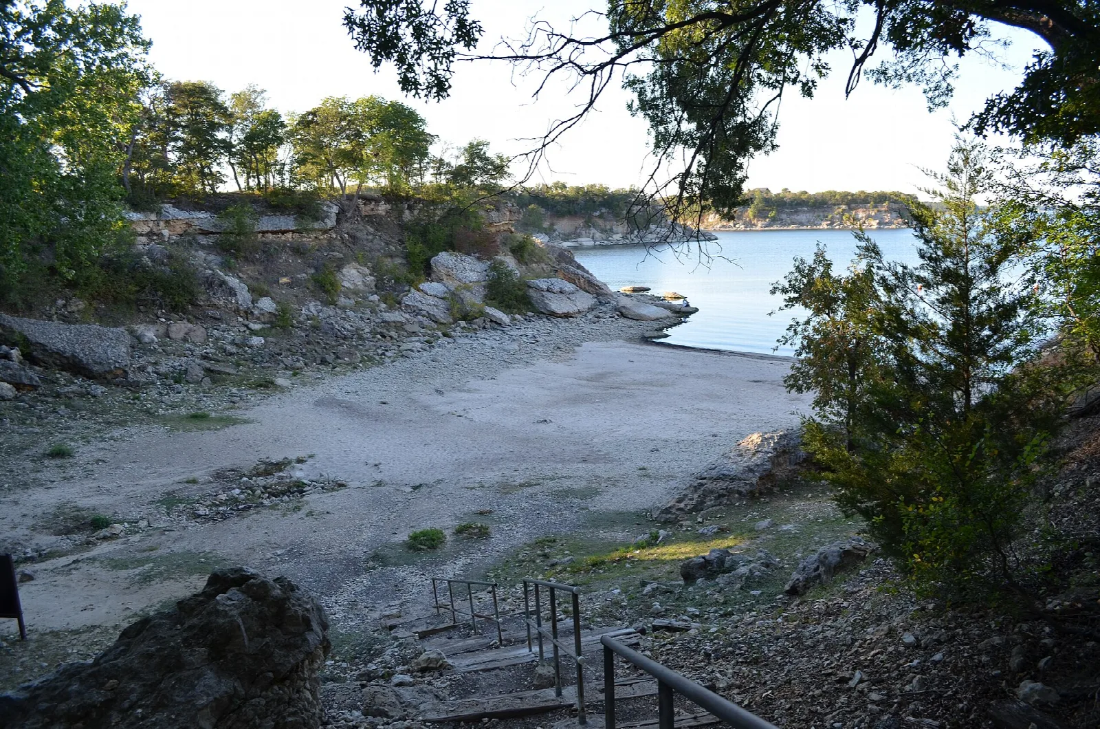 Lake shoreline with rocks and a path of steps down to the water