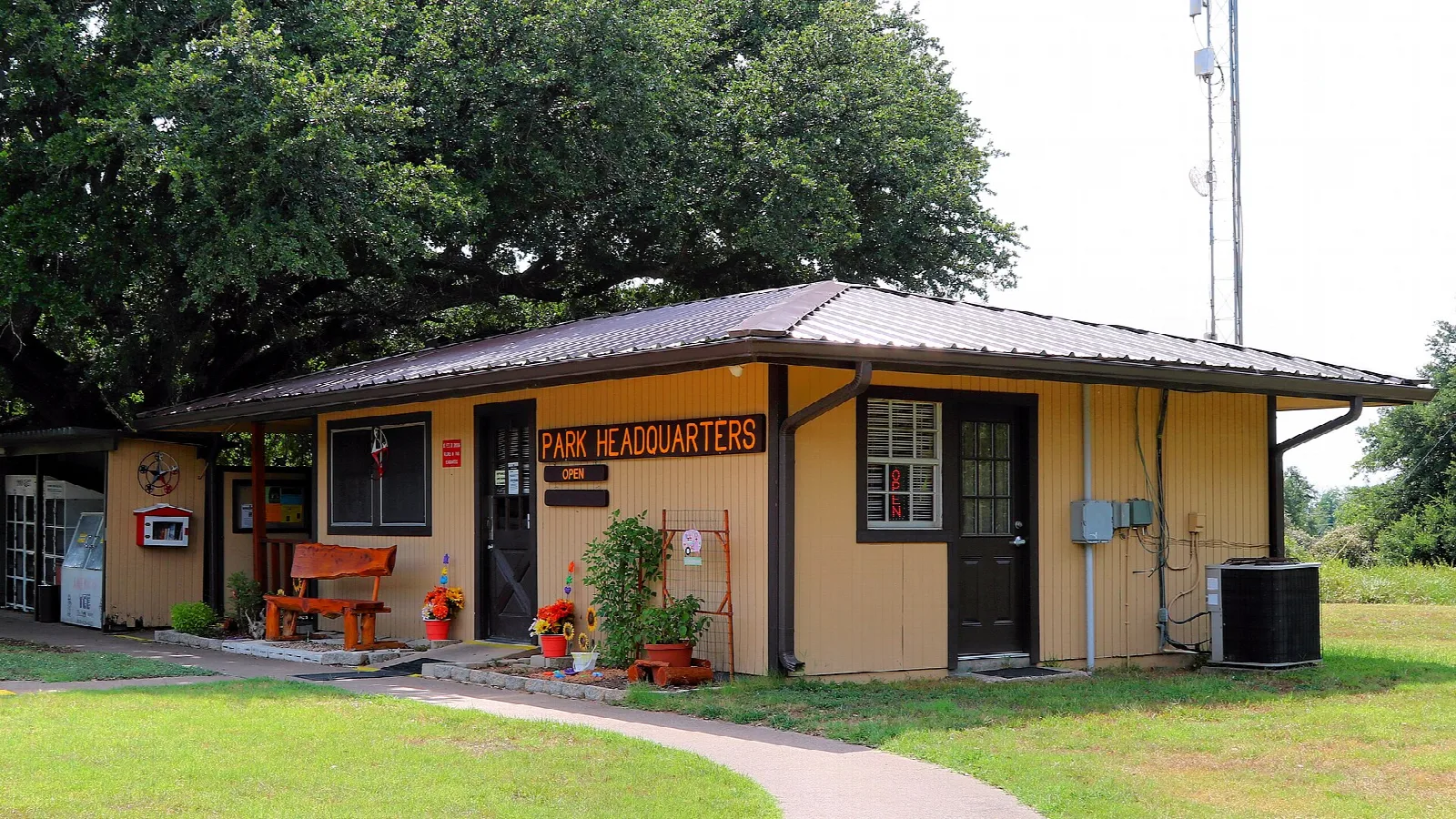 Small tan headquarters building with flowers by the door