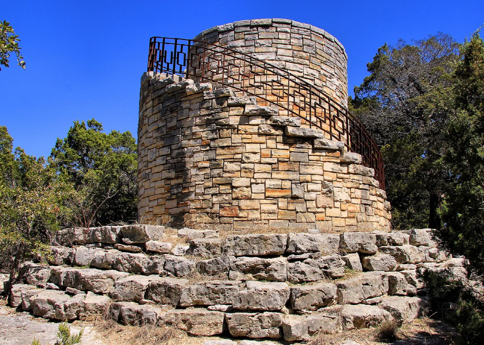 Round stone lookout tower and water tank among trees