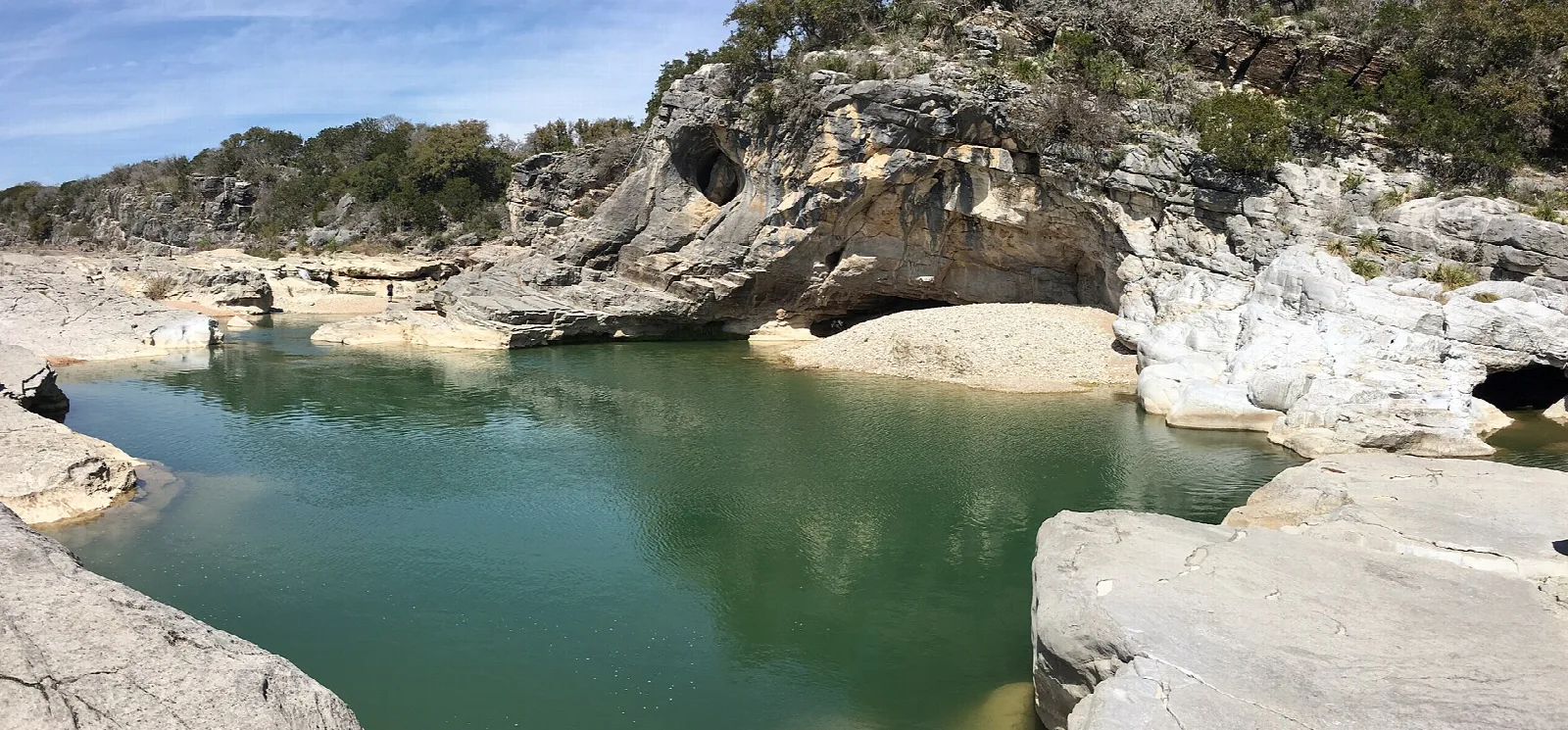 Green pool under a limestone ledge