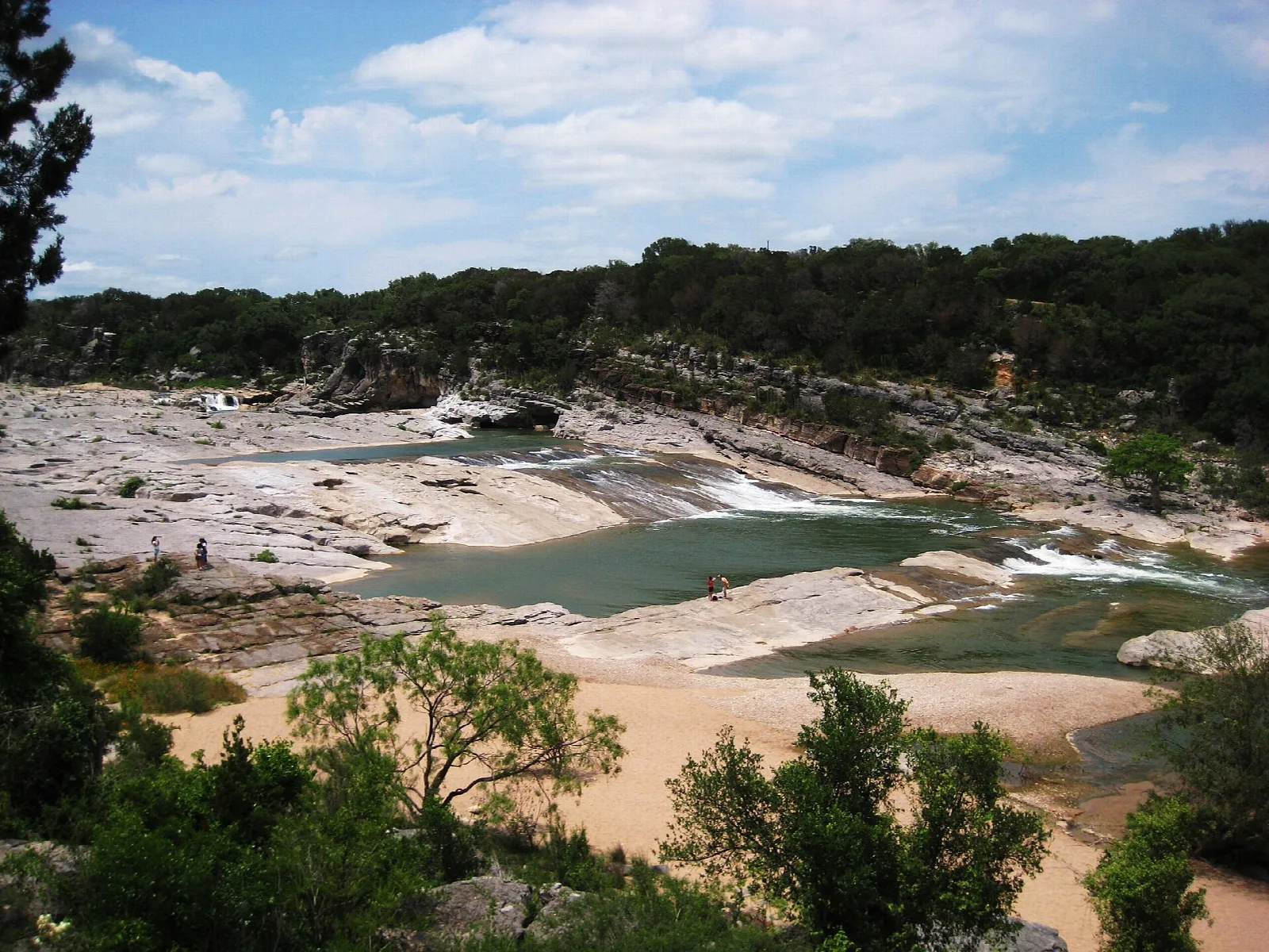 River channel with pale rock ledges and green trees