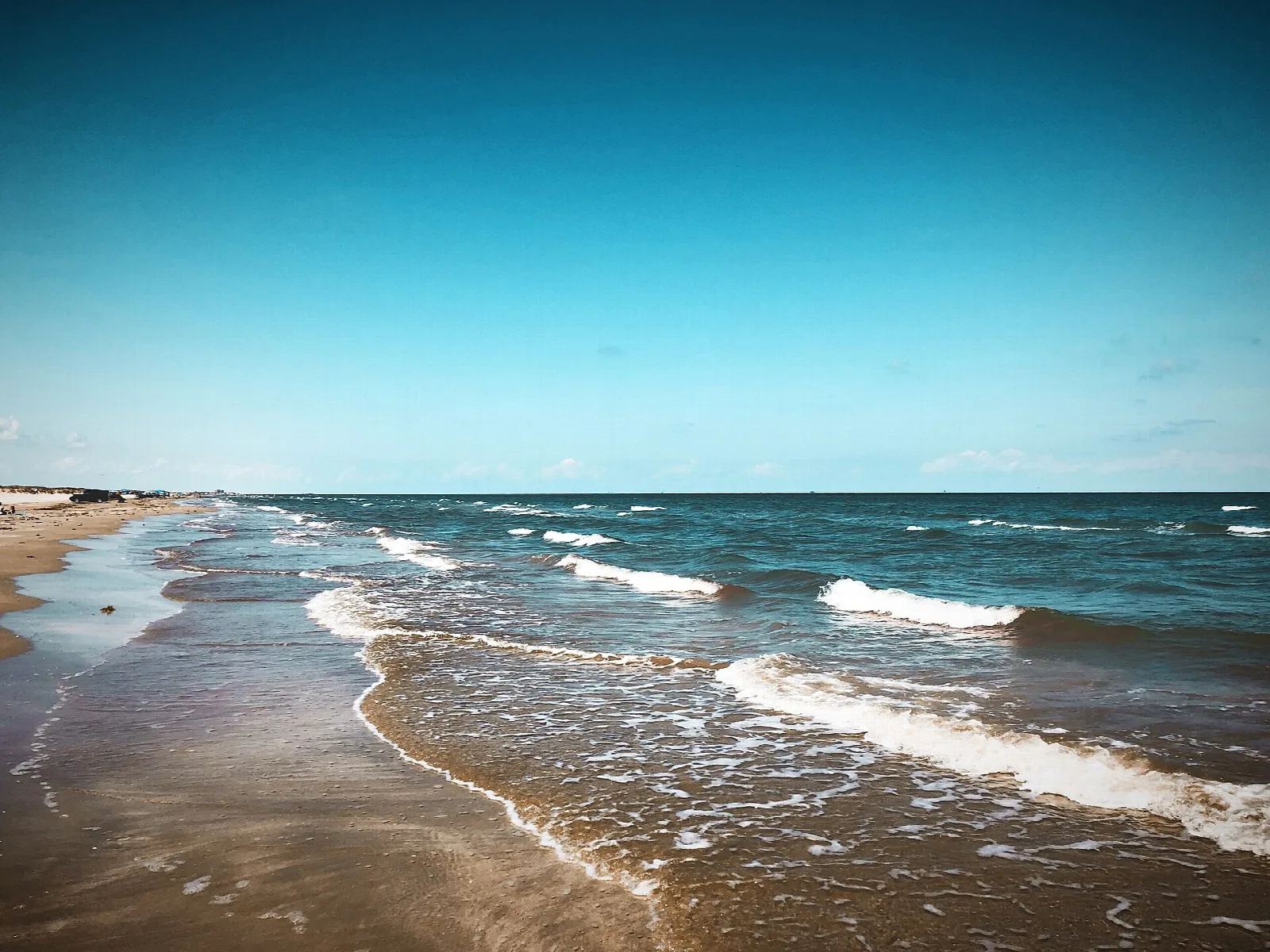 Waves washing onto a wide sandy Gulf beach