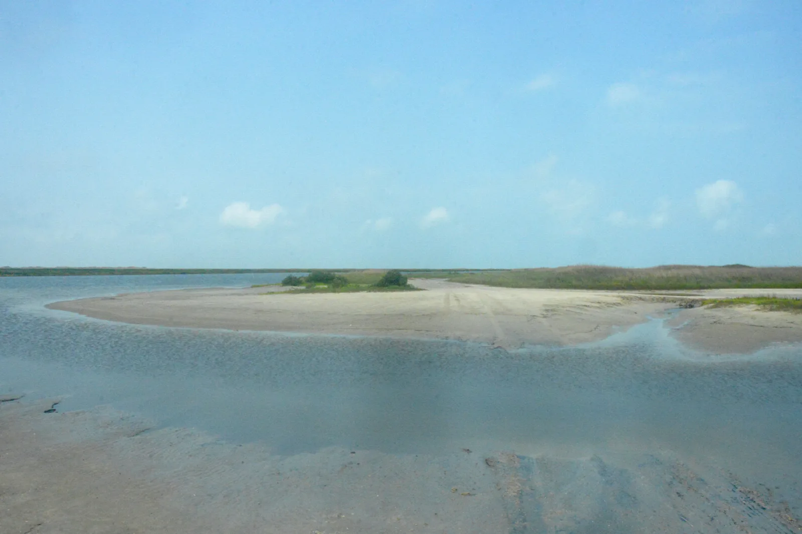 Sandbar and shallow tidal water with low dunes beyond