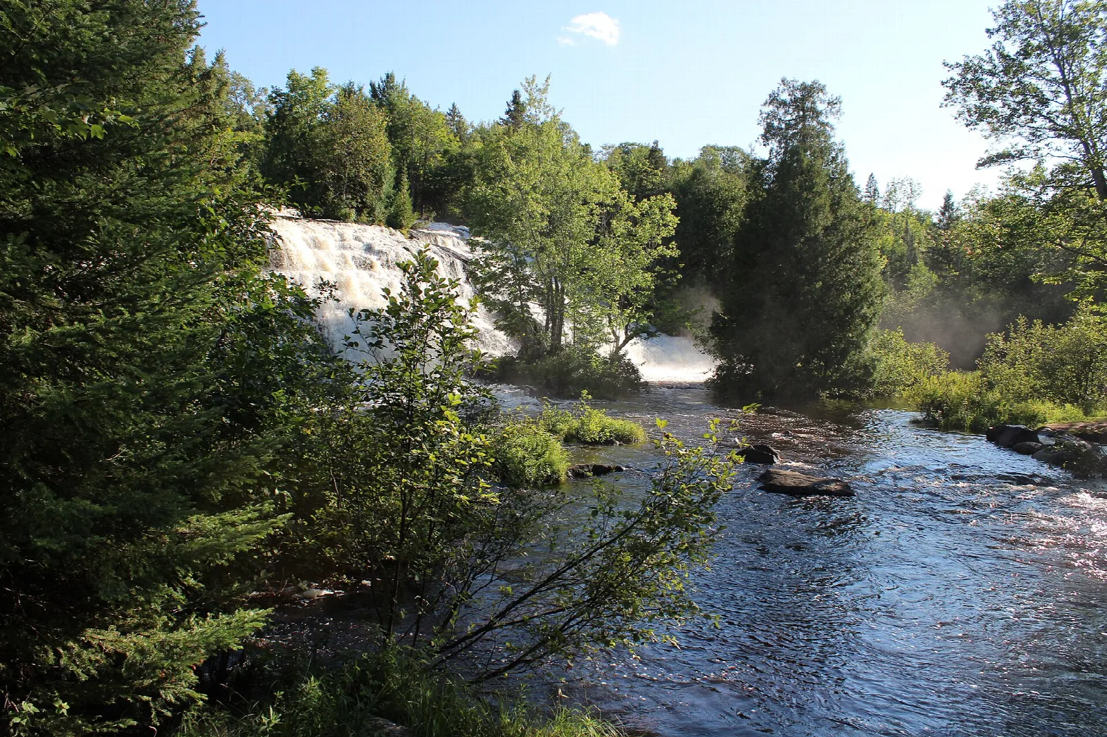 River in the foreground with the falls and mist in the distance