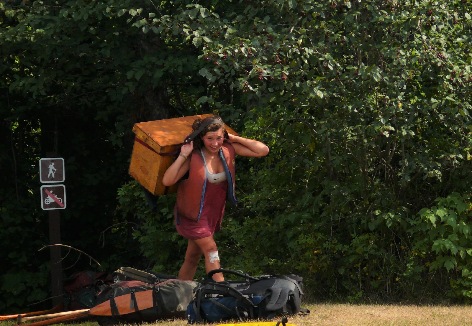 A person carrying a large box held in place with a head strap.