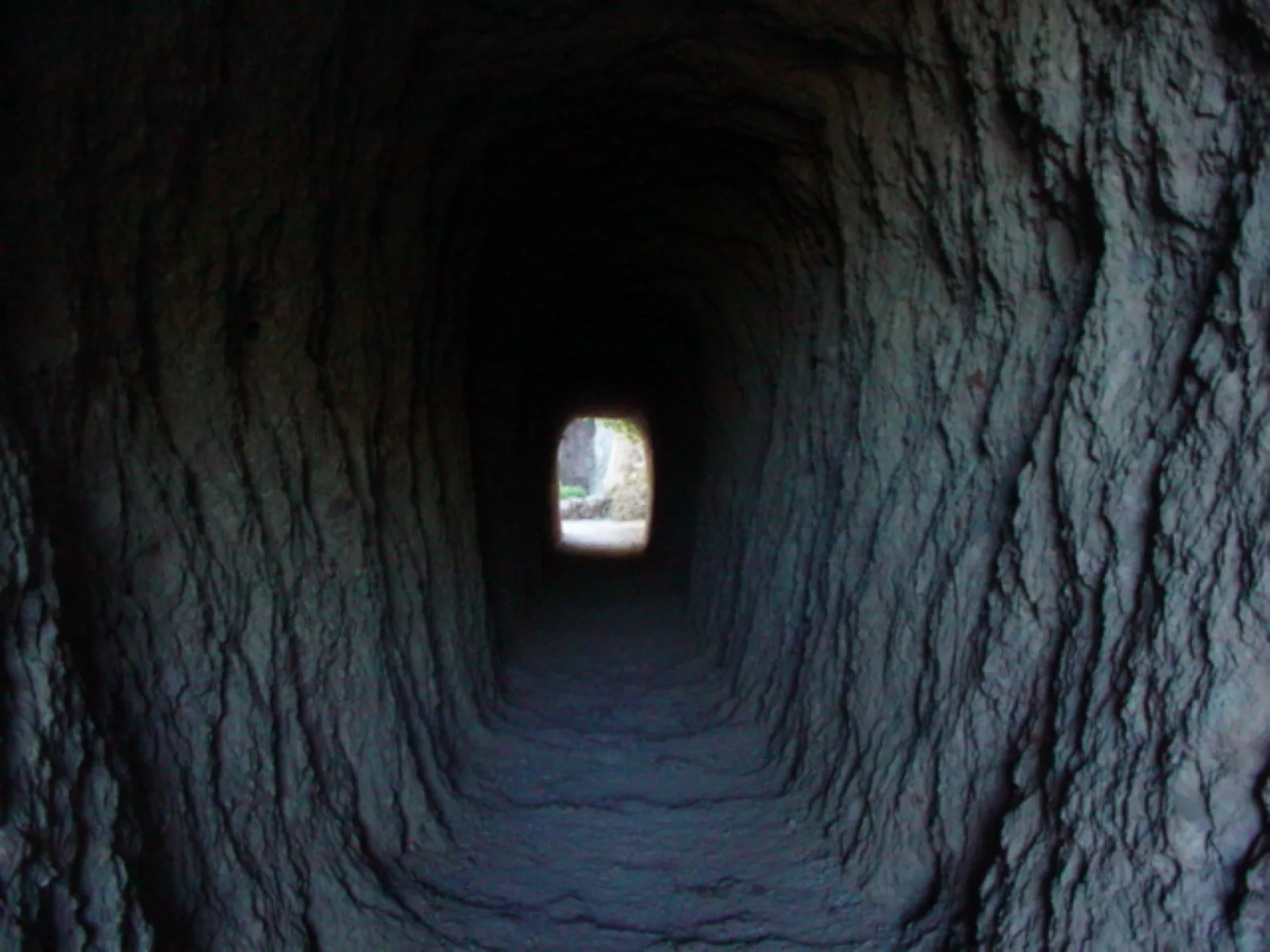 Natural light luminating the walls inside a manmade rock tunnel